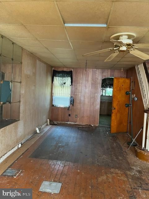 spare room featuring ceiling fan, wooden walls, and dark hardwood / wood-style flooring