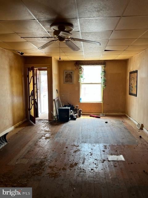 interior space with ceiling fan, wood-type flooring, and a drop ceiling