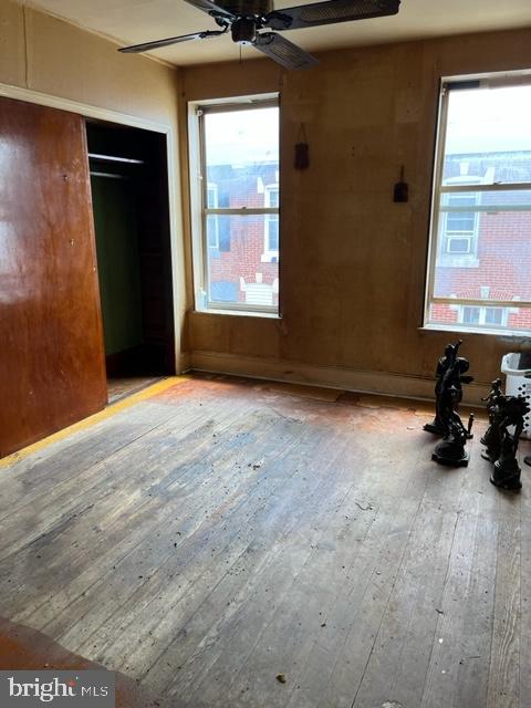 unfurnished bedroom featuring light hardwood / wood-style flooring, a closet, and ceiling fan