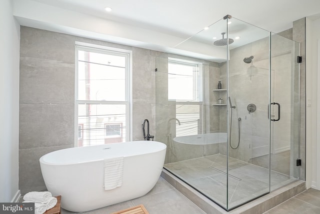 bathroom with a healthy amount of sunlight, tile patterned floors, and separate shower and tub