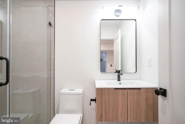 bathroom with vanity, toilet, and a shower with shower door