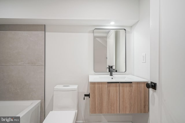 bathroom featuring toilet, vanity, and a bathtub