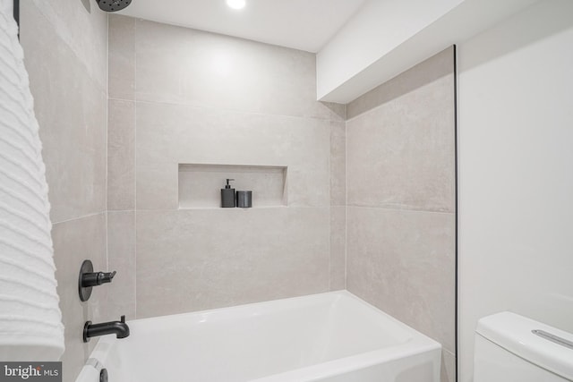 bathroom featuring toilet and tiled shower / bath combo