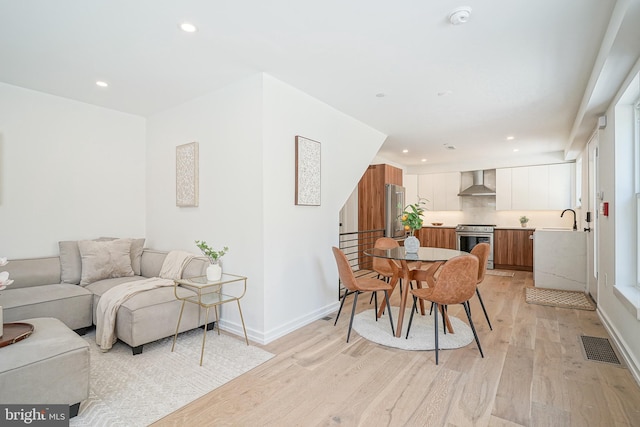 dining space featuring sink and light hardwood / wood-style floors