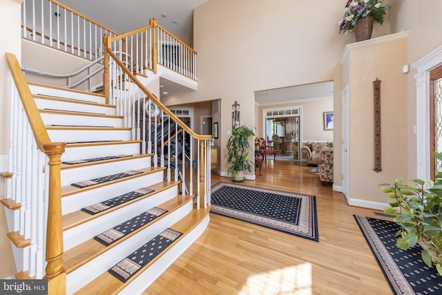 foyer entrance featuring light hardwood / wood-style flooring and a high ceiling