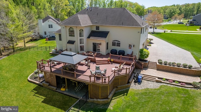 back of house featuring a deck and a lawn