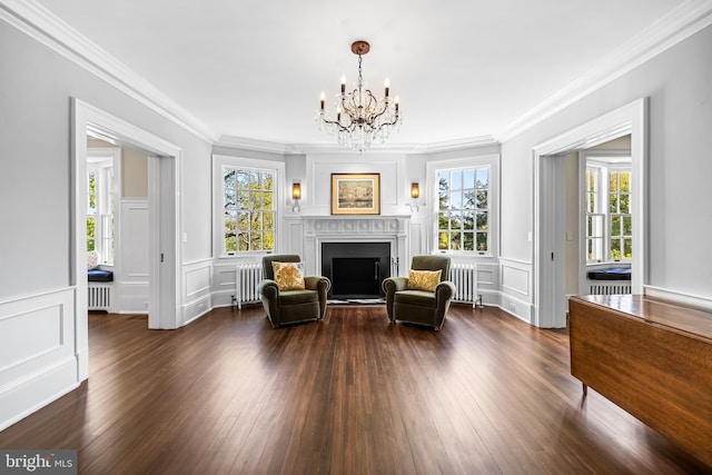 sitting room featuring dark hardwood / wood-style flooring, crown molding, radiator heating unit, and a wealth of natural light