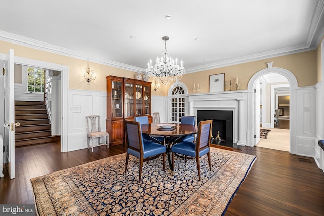 dining area featuring crown molding, dark hardwood / wood-style floors, and a notable chandelier