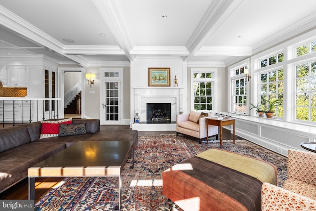 living room featuring beam ceiling, coffered ceiling, ornamental molding, and wood-type flooring