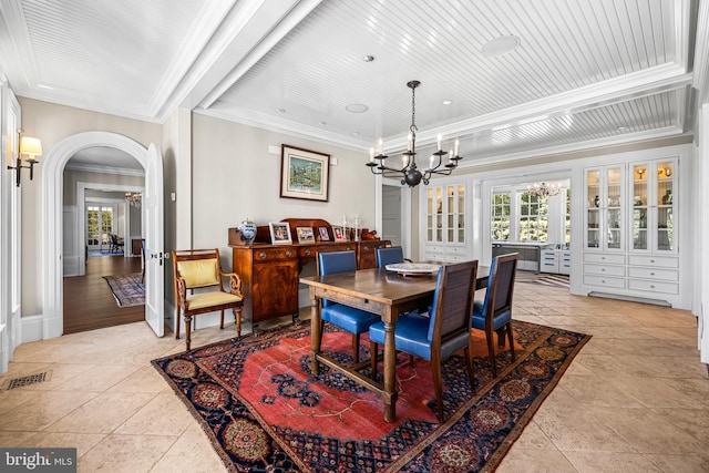 dining area with crown molding, a chandelier, and light tile patterned floors