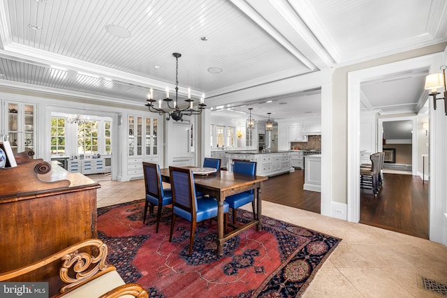 dining area featuring crown molding, a notable chandelier, light wood-type flooring, and french doors