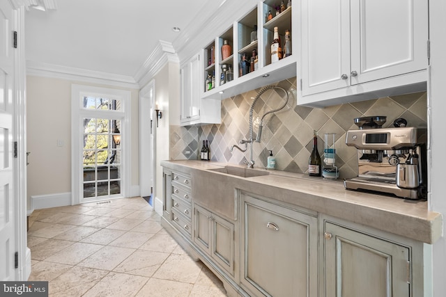 kitchen featuring ornamental molding, light tile patterned flooring, and backsplash