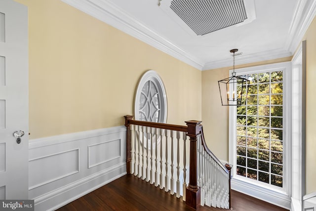 staircase with hardwood / wood-style floors, crown molding, and a chandelier