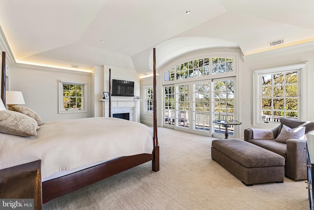 bedroom featuring access to outside, lofted ceiling, multiple windows, and light colored carpet