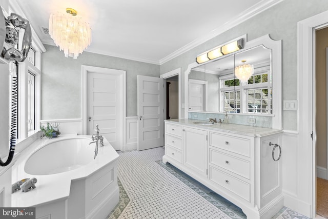 bathroom with vanity, crown molding, a tub, and a chandelier