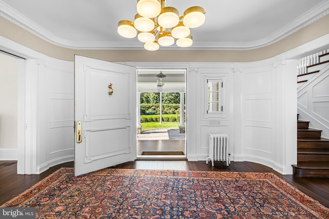 entryway featuring ornamental molding, dark wood-type flooring, radiator heating unit, and a chandelier