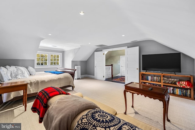 bedroom with lofted ceiling, light colored carpet, and radiator heating unit