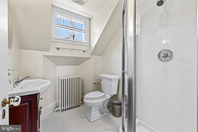 bathroom featuring a tile shower, radiator, toilet, vanity, and tile patterned flooring