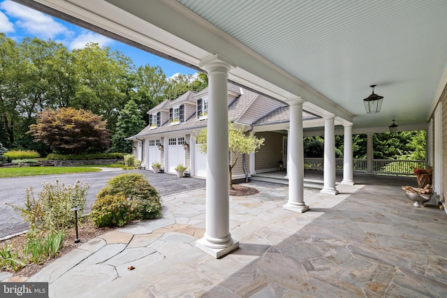 view of patio / terrace with a garage and a porch