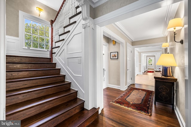 entrance foyer with crown molding and dark wood-type flooring