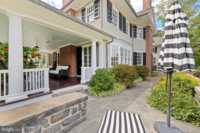 entrance to property featuring covered porch and ceiling fan