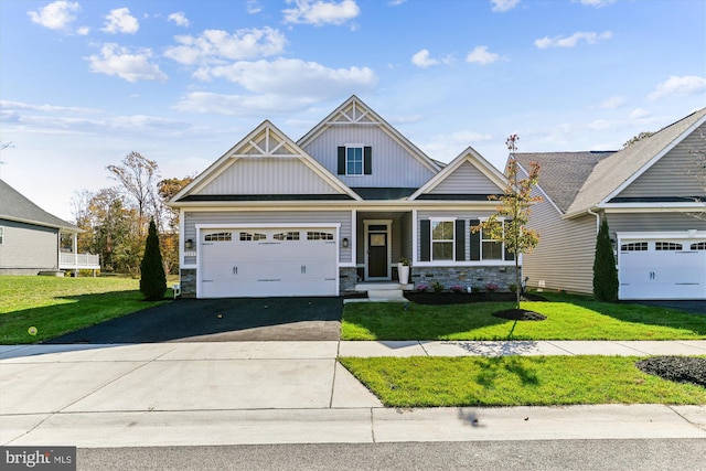 craftsman inspired home featuring a garage and a front lawn