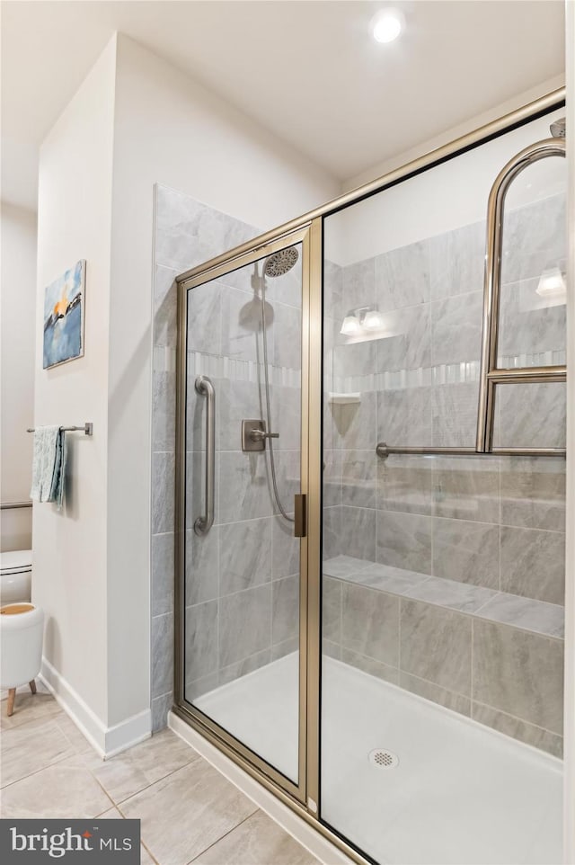 bathroom with toilet, tile patterned floors, and walk in shower