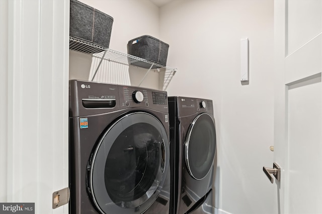 clothes washing area with washing machine and dryer