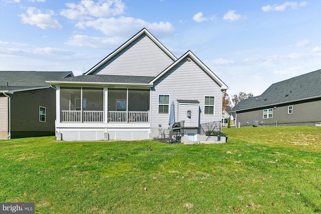 back of property with a yard, a patio area, and a sunroom