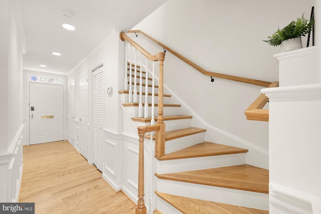 staircase with crown molding and hardwood / wood-style flooring