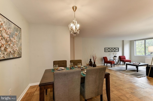 dining area featuring a notable chandelier and parquet floors