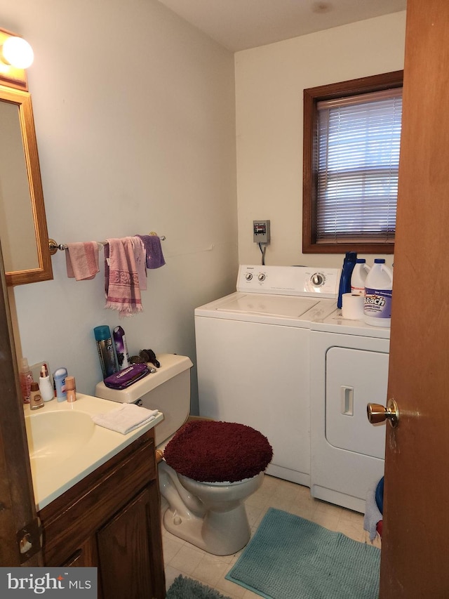 bathroom featuring vanity, toilet, separate washer and dryer, and tile patterned flooring