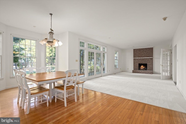 dining room featuring light hardwood / wood-style floors, a chandelier, and a fireplace