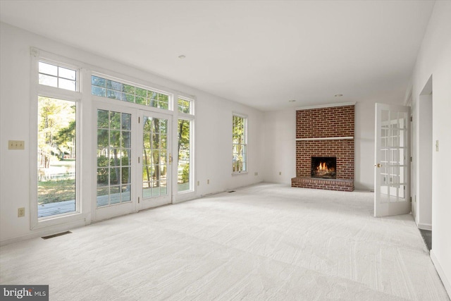 unfurnished living room featuring a fireplace and light colored carpet