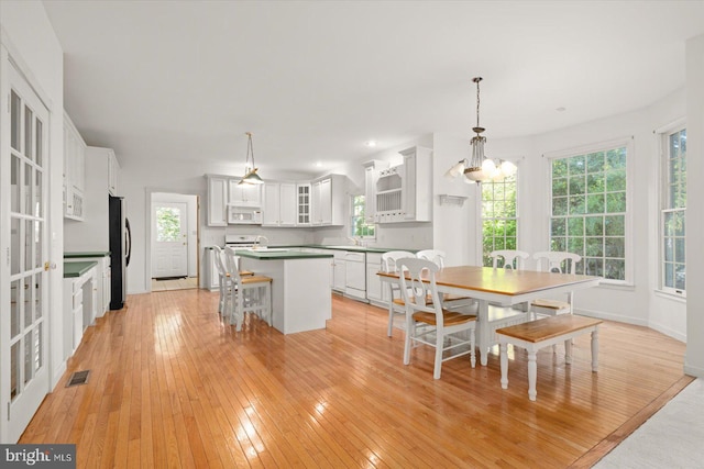 dining area with light hardwood / wood-style floors, a chandelier, and sink