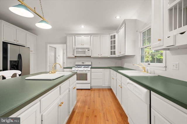 kitchen featuring white appliances, light hardwood / wood-style floors, white cabinetry, and sink