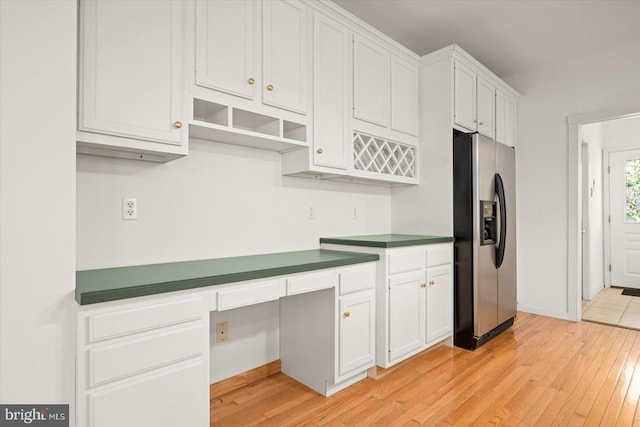 kitchen featuring built in desk, stainless steel fridge, white cabinets, and light hardwood / wood-style floors