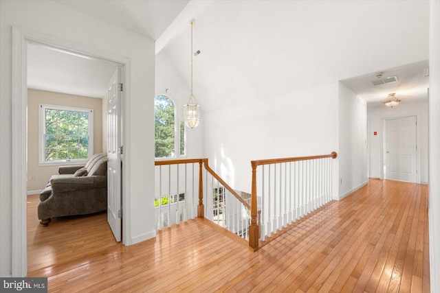 hall featuring vaulted ceiling and light hardwood / wood-style floors