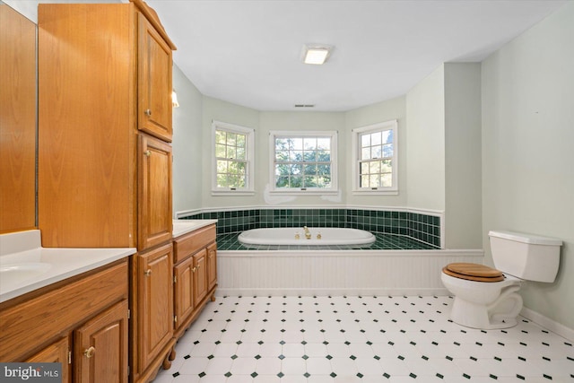 bathroom with toilet, a tub to relax in, and vanity