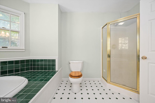 bathroom featuring toilet and shower with separate bathtub