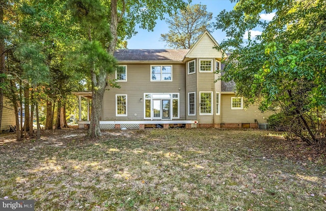 rear view of property with central air condition unit, a wooden deck, and a yard