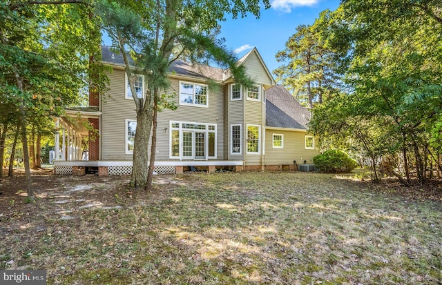 rear view of property with cooling unit and a lawn