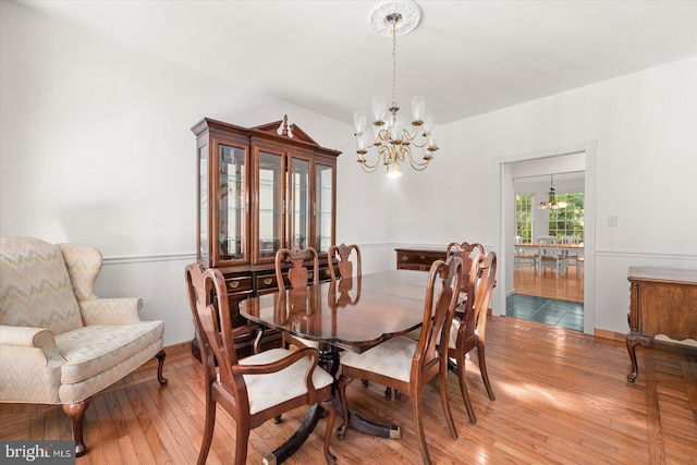 dining space featuring hardwood / wood-style flooring and a chandelier