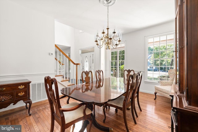 dining space featuring light hardwood / wood-style flooring and a chandelier