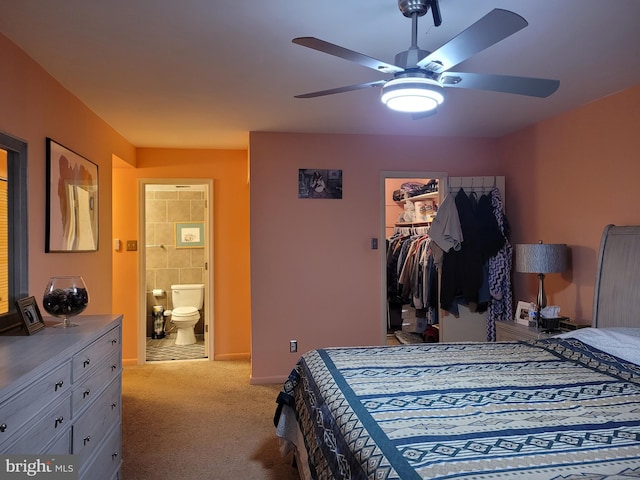 bedroom featuring light carpet, ceiling fan, a spacious closet, a closet, and ensuite bath