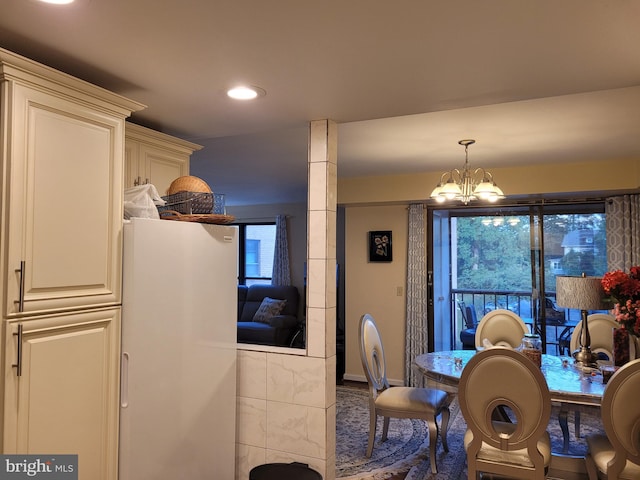 carpeted dining area with a chandelier