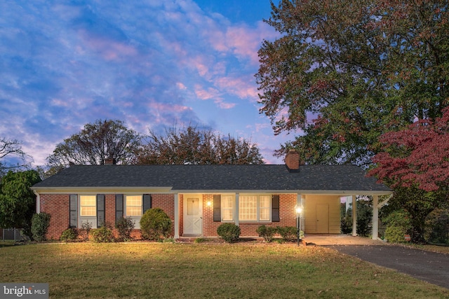 ranch-style house featuring a yard and a carport