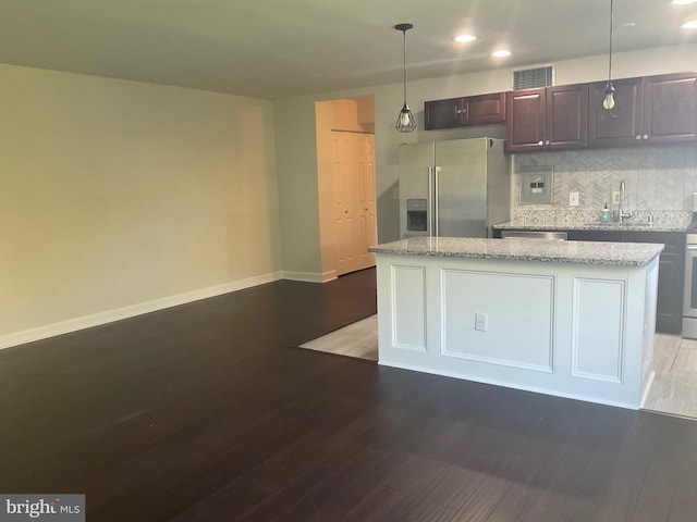 kitchen featuring a kitchen island, hardwood / wood-style flooring, hanging light fixtures, stainless steel fridge with ice dispenser, and dark brown cabinetry