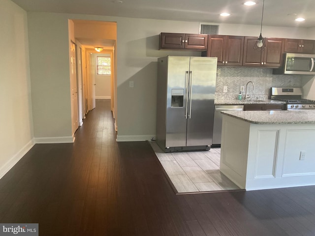 kitchen with stainless steel appliances, wood-type flooring, sink, and pendant lighting