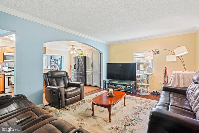 living room featuring crown molding, hardwood / wood-style flooring, and ceiling fan